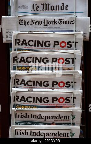 Zeitungen im Ausstellungsständer vor dem Zeitungsladen, UK - Racing Post, Le Monde, New York Times Stockfoto