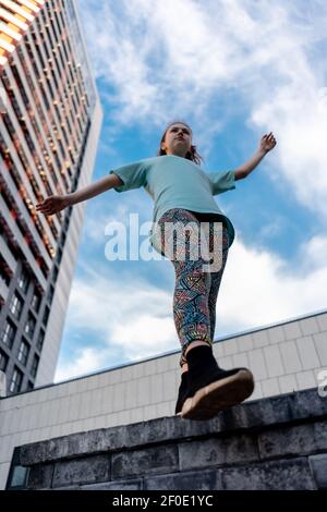 Blick von unten auf stilvolle Teenager in der Nähe Wolkenkratzer zu Fuß im Freien Stockfoto