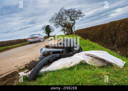 Leicestershire, England, Großbritannien – illegale Fliege kippen auf einer abgelegenen einspurigen Straße mit einem Auto vorbei Stockfoto