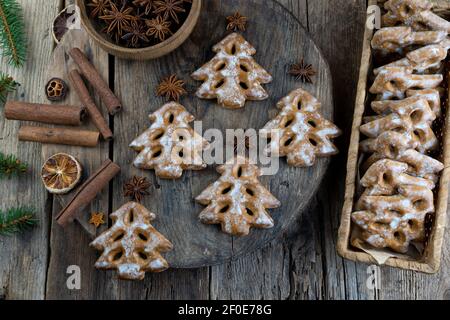 Christbaumkekse auf Holzhintergrund. Neujahrsessen. Anisstern. Festliche Backwaren. Lebkuchen auf dem Tisch.Puderzucker Süße Geschmack se Stockfoto