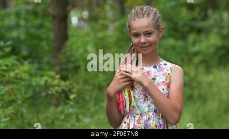 Teenager-Mädchen mit bunten Dreadlocks im Wald. Stockfoto