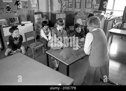 Teilhörgerät. Teilweise hörende Kinder, die in einer speziellen Einheit erzogen werden. Lehrer, der Unterricht im Klassenzimmer gibt. Stockfoto