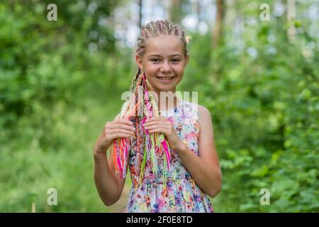 Teenager-Mädchen mit bunten Dreadlocks im Wald. Stockfoto