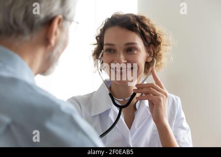 Lächelnd weibliche Krankenschwester untersuchen reifen männlichen Patienten Stockfoto