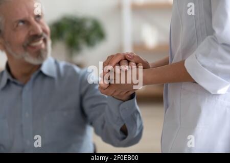 Unterstützende Krankenschwester tröstet älteren männlichen Patienten Stockfoto