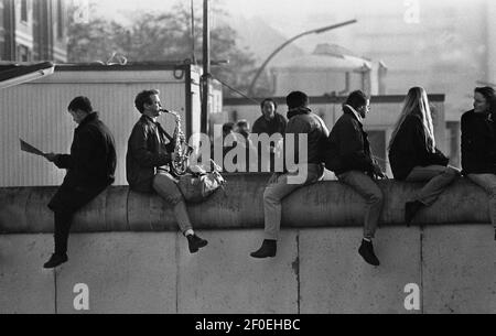 Berlin 12. November 1989. Blick von Osten nach Westen. Ein Ostberliner sitzt auf der Wand und spielt 'Misty' von Erroll Garner auf seinem Saxophon. Der Klang, der am ersten Sonntag nach dem Mauerfall in den ruhigen Straßen nachhallt. Die frühmorgendliche Wintersonne nahm die Kälte der Nacht weg. Ein schöner Morgen, erinnert 20 Jahre später. Wo ist der Saxophonspieler?COPYRIGHT FOTO VON BRIAN HARRIS 07808-579804 Stockfoto