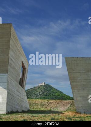 PAVLOV, TSCHECHISCHE REPUBLIK - 23. Juli 2021: Betongebäude des Archeoparks Pavlov, modernes Museum mit Blick auf den Hügel mit Ruinen der Burg Devicky. Stockfoto