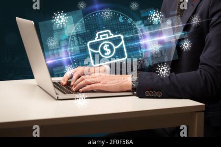 Business Hand arbeiten an der Börse mit Aktenkoffer Symbole kommen Aus dem Laptop-Bildschirm Stockfoto