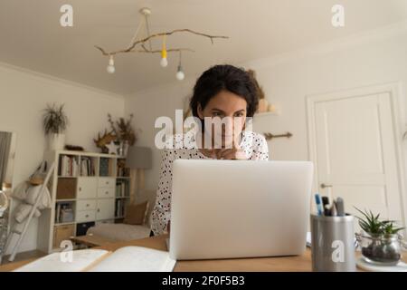 Nachdenkliche weibliche Arbeit auf Laptop von zu Hause Blick auf den Bildschirm Stockfoto