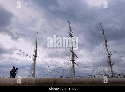 Hamburg, Deutschland. März 2021, 07th. Bei bewölktem Wetter fotografieren sich Touristen an der Elbpromenade in Hamburg vor einem historischen Segelschiff. Es wird erwartet, dass es in den kommenden Tagen in der Hansestadt bewölkt und kühl bleiben wird. Quelle: Ulrich Perrey/dpa/Alamy Live News Stockfoto