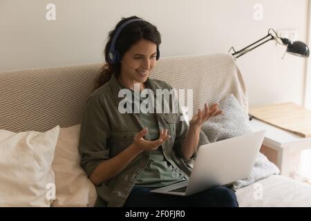 Lächelnde lateinische Dame sprechen vor pc-Bildschirm bieten Nachhilfe-Service Stockfoto