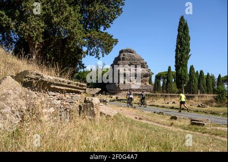 Rom. Italien. Via Appia Antica (Appian Way), Menschen zu Fuß und mit dem Fahrrad zwischen alten römischen Grabdenkmälern. Das sogenannte Pyramid Mausoleum Stockfoto