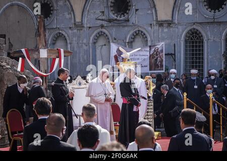 Mosul, Irak. März 2021, 07th. Papst Franziskus (C) führt ein Gebet zum Gedenken an die Opfer der Terrorgruppe des sogenannten Islamischen Staates (IS) in Hosh al-Bieaa, einem Platz, der aus vier Kirchen besteht, die in Alt-Mossul stark beschädigt sind. Papst Franziskus kam am Freitag zum ersten Papstbesuch im Nahen Osten in den Irak, wo die christliche Gemeinschaft in Kriegsjahren geschrumpft ist. Quelle: Ismael Adnan/dpa/Alamy Live News Stockfoto