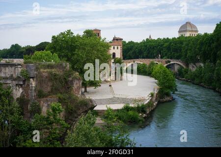 Zwischen den grünen Ufern voller Bäume, die Tiber Insel, Fabricio Brücke und der Tiber Fluss, die Emilio Brücke, in Rom genannt Ponte Rotto, Stockfoto