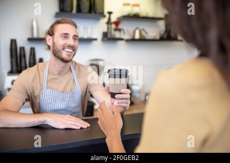 Mann hält der Frau ein Glas Kaffee Stockfoto