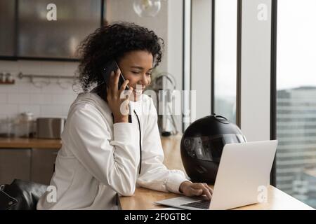 Nahaufnahme afroamerikanische Frau, die am Telefon spricht, mit Laptop Stockfoto