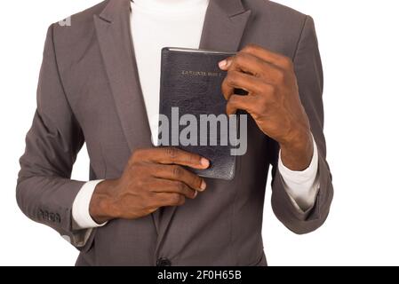 Nahaufnahme einer Person, die eine Bibel hält, die er der Kamera präsentiert. Stockfoto