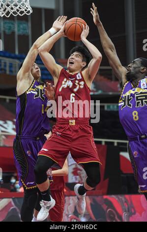 (210307) -- ZHUJI, 7. März 2021 (Xinhua) -- Cheng Shuaipeng (C) von Zhejiang Golden Bulls geht in den Korb an Wang Shaojie (L) und Ekpe Udoh von Peking Royal Fighters während der Runde 42nd Spiel zwischen Zhejiang Golden Bulls und Peking Royal Fighters bei der Saison 2020-2021 der chinesischen Basketball Association (CBA) Liga in Zhuji, die Provinz Zhejiang in ostchina, 7. März 2021. (Xinhua/Jiang Han) Stockfoto