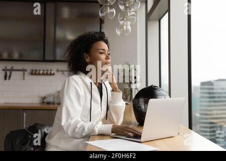 Nahaufnahme nachdenkliche afroamerikanische Geschäftsfrau, die aus dem Fenster schaut Stockfoto