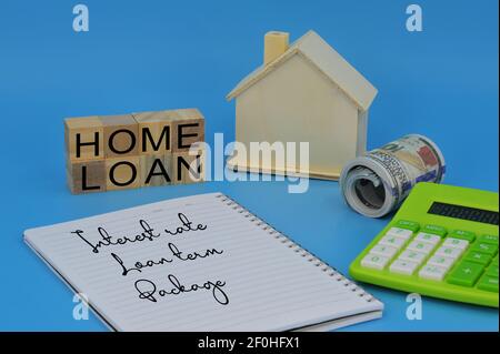 Layout von Haus-Modell, gefälschte Geld, Notizbuch, Rechner und Holzwürfel mit Text HOME LOAN. Finanz- und Geschäftskonzept. Selektive Fokuspunkte Stockfoto