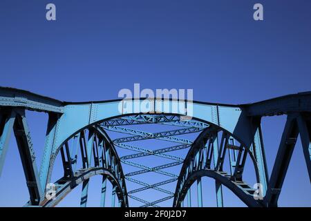 Niedrige Winkelansicht auf isoliertem symmetrischem Stahlbrückendeck Gegen blauen Himmel mit Kreuzstreben und Metallbalken Stockfoto