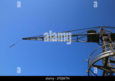 Low-Winkel-Ansicht auf isolierten alten Stahl Kranträger gegen Wolkenloser tiefblauer Himmel Stockfoto