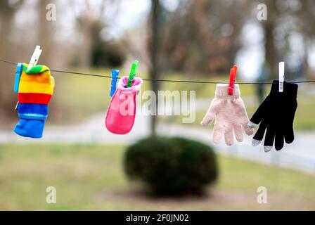 Braunschweig, Deutschland. März 2021, 07th. Einzelne Handschuhe, die von Spaziergängern im Museumspark verloren gegangen sind, werden mit Wäscheklammern an einer Linie nahe dem Staatstheater in der Innenstadt aufgehängt. Dies gibt Besitzern die Möglichkeit, ihren verlorenen Handschuh leichter zu finden. Quelle: Hauke-Christian Dittrich/dpa/Alamy Live News Stockfoto