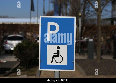 Nahaufnahme von isolierten blau weiß für behinderte Menschen Parkplatz Schild reserviert, verschwommener Hintergrund Stockfoto