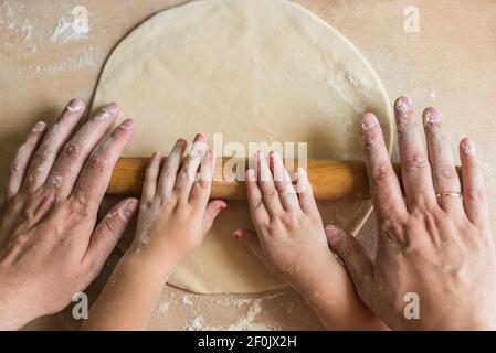 Kinder und Papa Händen Teig gerollt Stockfoto