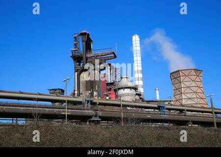 Duisburg (ruhrgebiet), Deutschland - März 1. 2021: Blick auf Industriekomplex mit rauchenden Schornsteinen und Turm gegen blauen Himmel - Thyssen Krupp Steel comp Stockfoto