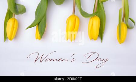 Glückliche Frauen Tag Text-Zeichen auf Tulpen weißen Hintergrund. Stilvolle Wohnung lag mit Blumen mit Platz für Text. Grußkarte. hallo Frühling. Stockfoto