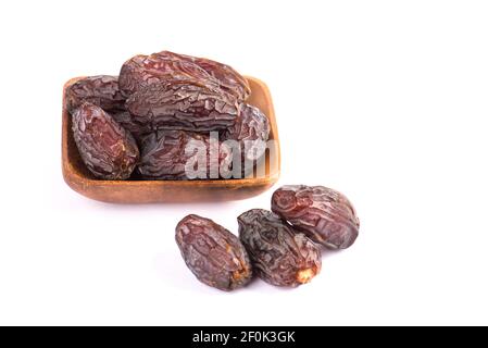 HURMA, Termine. Getrocknete Datteln Obst mit Holzplatte auf weißem Hintergrund. Beliebte Frucht des Ramadan. Stockfoto