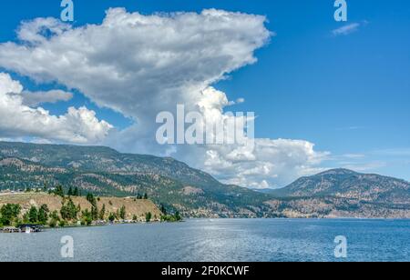 Okanagan See und Berge Übersicht auf bewölktem Himmel Hintergrund Stockfoto