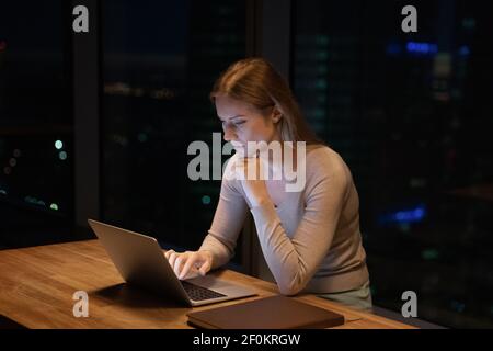 Nahaufnahme nachdenkliche Geschäftsfrau mit Laptop, arbeiten in der Nacht Stockfoto