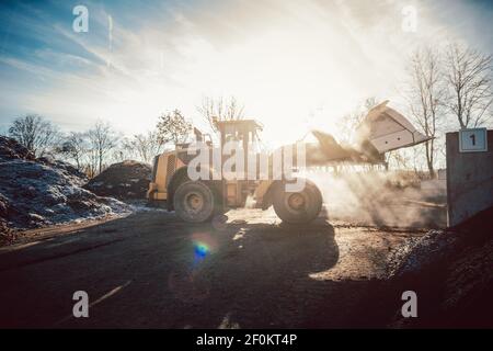 Bulldozer, der zur Kompostierung die Biomasse auf den Stapel legt Stockfoto