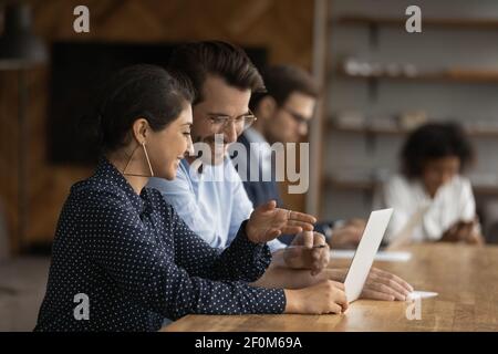 Lächelnde indische Geschäftsfrau Mentor Ausbildung neuer Mitarbeiter, mit Laptop Stockfoto