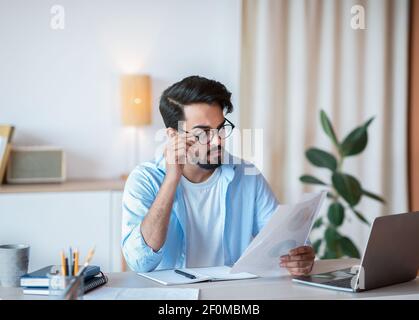 Junge Eastern Geschäftsmann In Brillen Arbeiten Mit Papers Und Laptop Im Büro Stockfoto