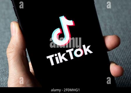 TikTok-Anwendungssymbol auf dem Apple iPhone 11-Bildschirm Nahaufnahme. Hand halten Smartphone mit Tik Tok Symbol. TikTok Social Media Netzwerk aus China. Stockfoto