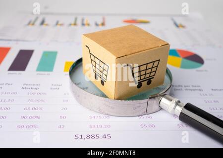 Warenkorb-Box mit Lupe auf Diagramm-Hintergrund, Business Import Export Investition Online-Finanzierung Konzept. Stockfoto