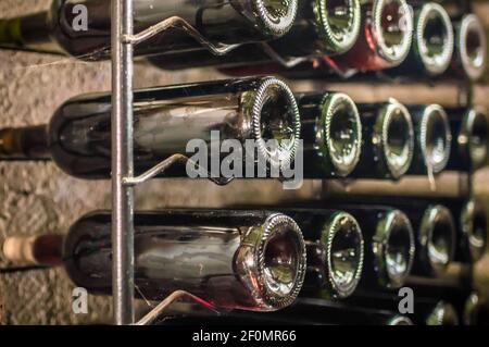 Flaschen Rotwein auf Eisenregal Stockfoto