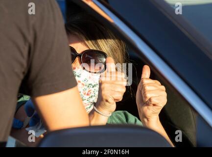 Round Rock, TX USA 6. März 2021: Eine geimpfte Frau gibt einen doppelten Daumen nach oben, als Williamson County einen 24-stündigen Impfmarathon veranstaltet, um mit dem COVID-19 Impfplan nach dem verheerenden Wintersturm im letzten Monat, der einen Großteil von Texas lahmlegte, Schritt zu halten. Ziel war es, bis zu 7.000 Texaner mit ersten oder zweiten Moderna-Dosen zu impfen. Kredit: Bob Daemmrich/Alamy Live Nachrichten Stockfoto