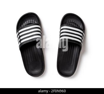 Schwarze Gummischuhe isoliert auf weiß. Paar Slide Sandalen Nahaufnahme. Leichte Schuhe für Pool oder Dusche. Komfortable Badeschuhe für den heißen Sommer. Stockfoto