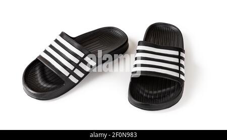 Paar Slidesandalen auf weiß isoliert. Schwarze Gummi Hausschuhe Nahaufnahme. Leichte Schuhe für Pool oder Dusche. Komfortable Badeschuhe für den heißen Sommer. Stockfoto