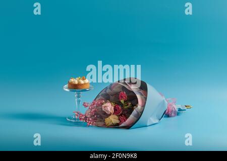 Trockene Blumen und Kuchen auf blauem Hintergrund Stockfoto