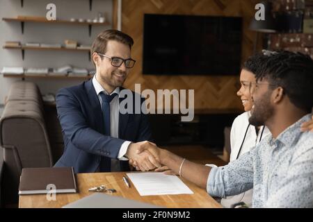 Nahaufnahme lächelnder Manager und afroamerikanisches Paar handshaking Stockfoto