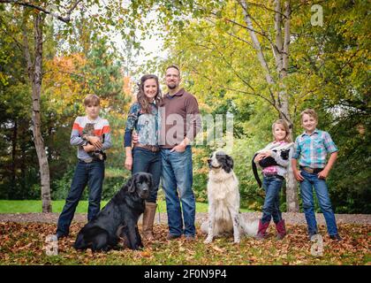Glückliche Familie von fünf mit Hunden und Katzen an einer Landstraße. Stockfoto