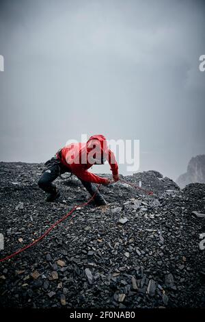 Mann unter Gewitter beim Klettern auf der Eiger Nordwand, Schweiz Stockfoto