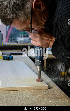 Mann in Gläsern, der mit Bohrer arbeitet Stockfoto