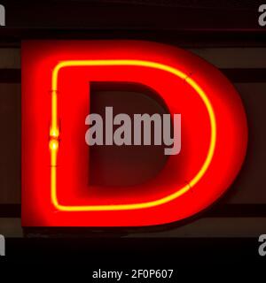 Rot glühender Neonbuchstabe D in der Nacht Stockfoto