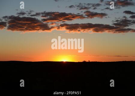 Gelbe und orange Sonnenuntergangslandschaft in namibischer Wüste mit Wolken Von orange und lila schwebt über horizontalem Format Raum für Geben Sie das Postkartenbild ein Stockfoto